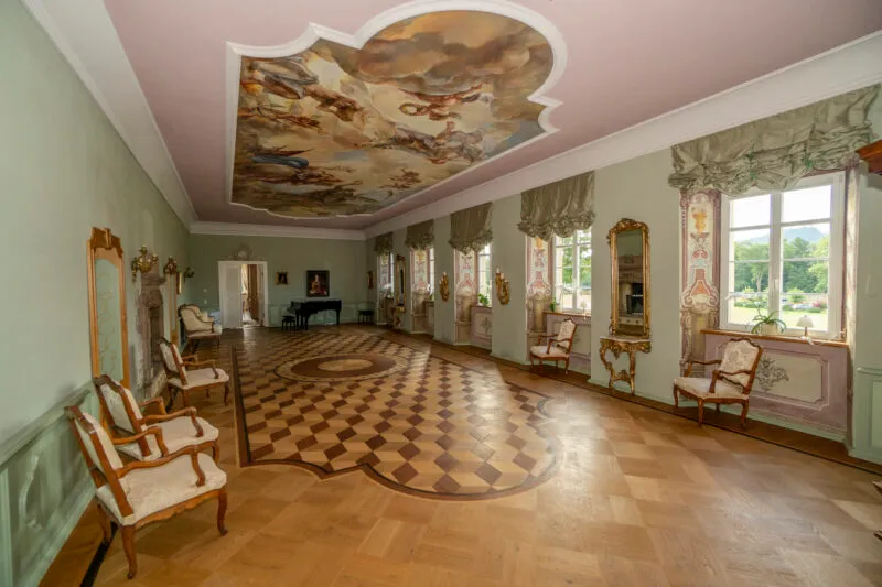 Stylowe, historyczne wnętrze komnat pałacowych, w których głównym dominantem są bogato zdobione wnęki okienne, sufit oraz drewniany parkiet. 