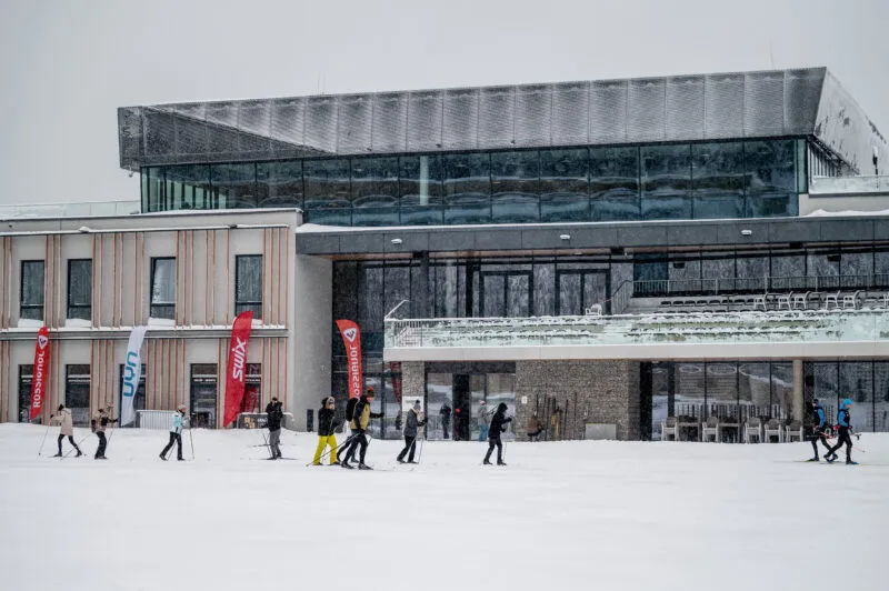 Narciarze biegowi przed budynkiem Dolnośląskiego Centrum Sportu Polana Jakuszycka