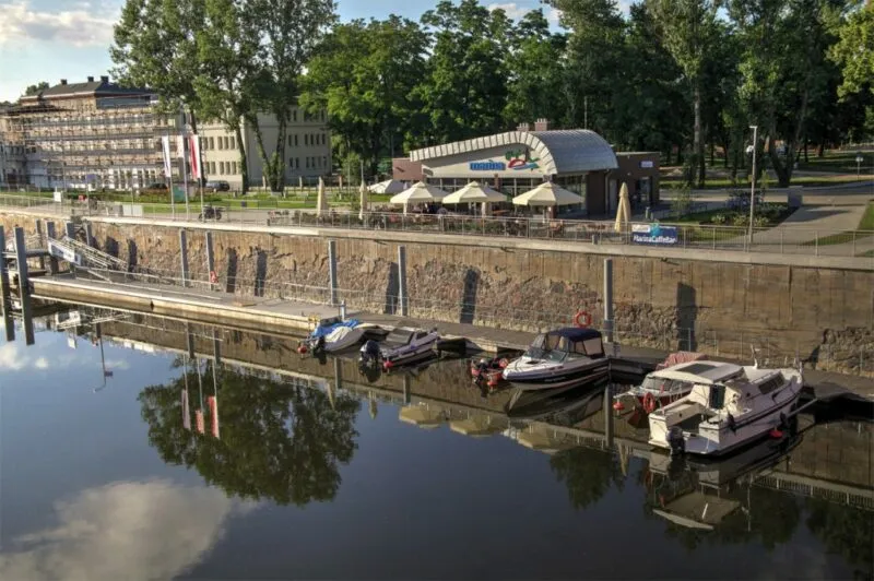 Przystań z łodziami, restauracją wśród drzew.