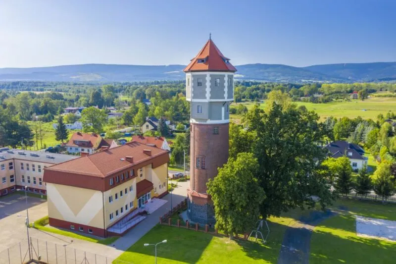 Widok z lotu ptaka na ceglano-kamienną, poniemiecką wieżę ciśnień, która obecnie jest wieżą widokową.