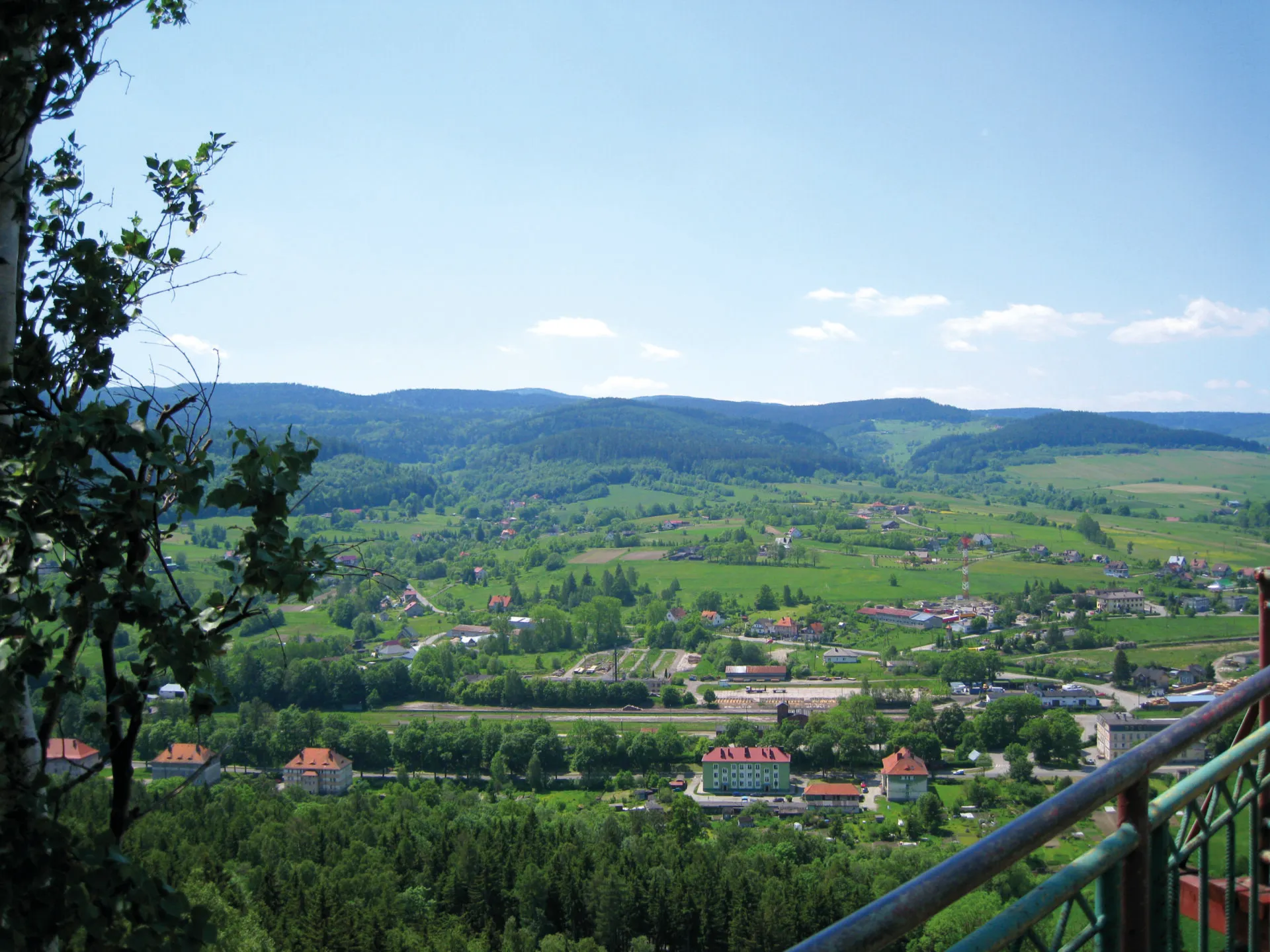 Widok na miejscowość Szczytna z widoczną linią kolejową i górami w tle