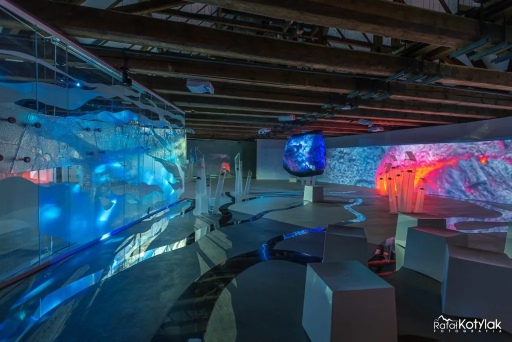 La salle multimédia du Centre naturel et éducatif de Sobieszów dispose de estrades irrégulières, de projections de rochers et d'eau, ainsi que d'expositions éclairées en bleu et en rouge.