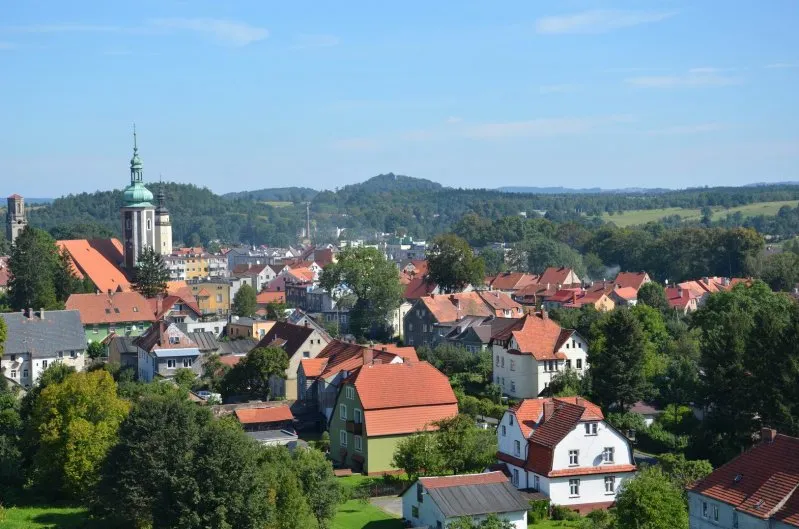 Widok na miasteczko oraz pogórze w malowniczy słoneczny dzień.