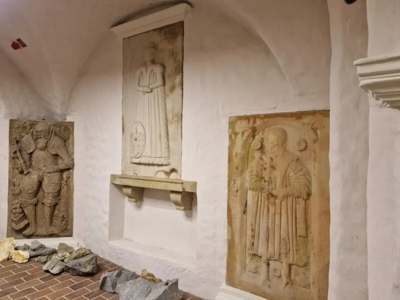 Wnętrze dawnego budynku- z kamiennymi rzeźbionymi obrazami zamonotowanymi na ścianach