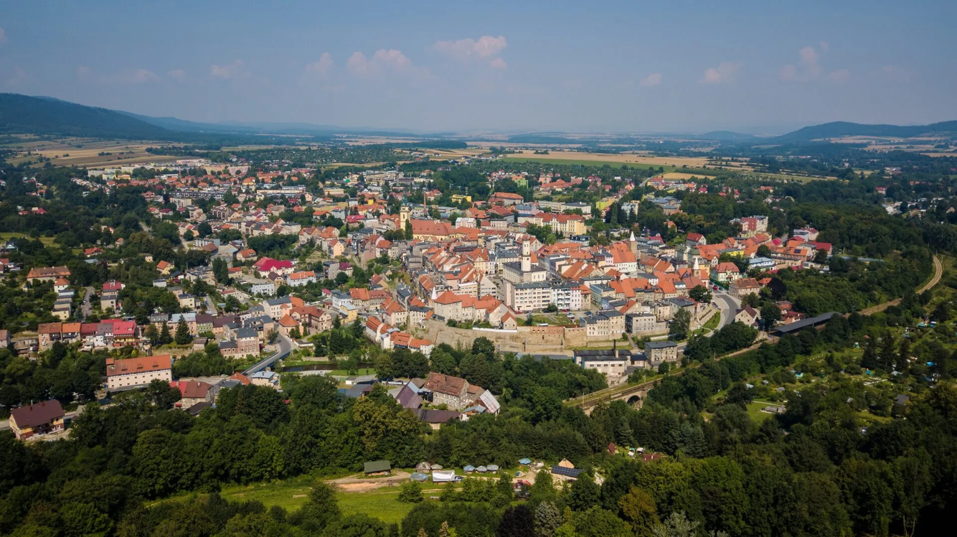 Widok z lotu ptaka na miasto, wokół zieleni.