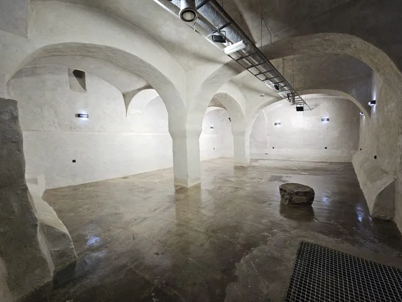 La luminosa sala sotterranea dell'ex birrificio di Bystrzyca Kłodzka ha volte in pietra sostenute da massicci pilastri e un pozzo circolare nel pavimento.
