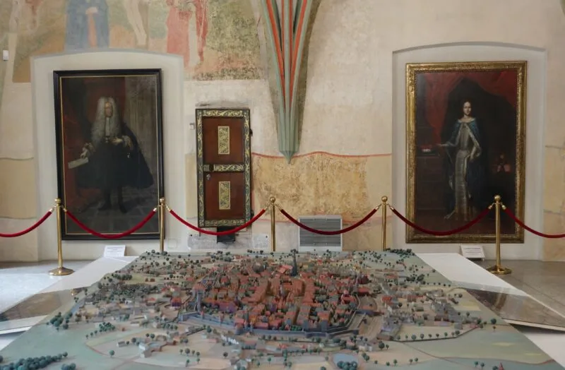 stara makieta miniaturowa ukazująca dawne miasto. w tle widać obrazy