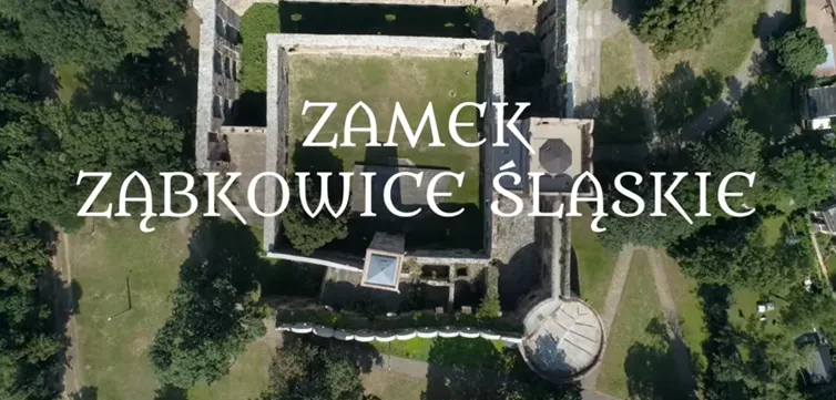 widok z lotu ptaka na zamek, na zdjęciu wyróżniają się kwadratowe mury zamku oraz w prawym dolny rogu znajduję się wieża widoczna z góry jako okrąg