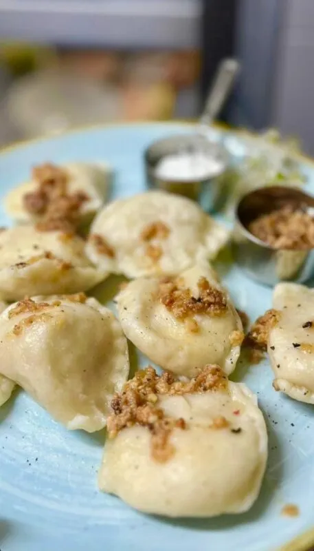 Pierogi podane na niebieskim talerzu.