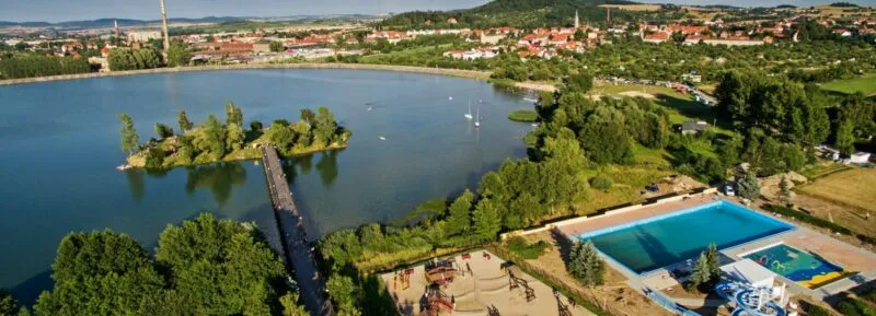 Widok z lotu ptaka na Jezioro Bielawskie, otoczone domkami oraz zielenią.