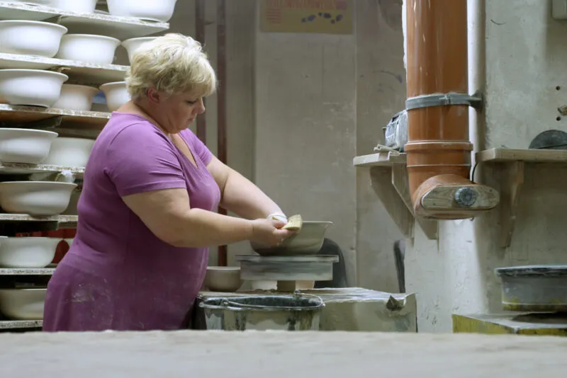 Kobieta w różowym stroju podczas pracy w fabryce porcelany