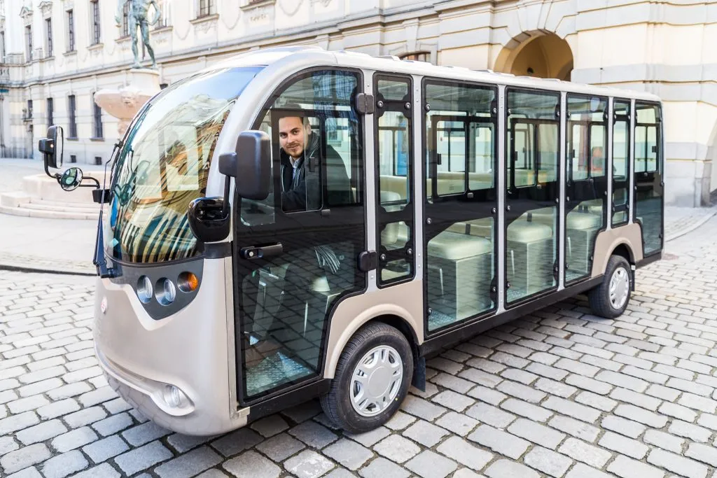 Pojazd elektryczny z kierowcą zaparkowany na starej kostce otaczanej w centrum Wrocławia