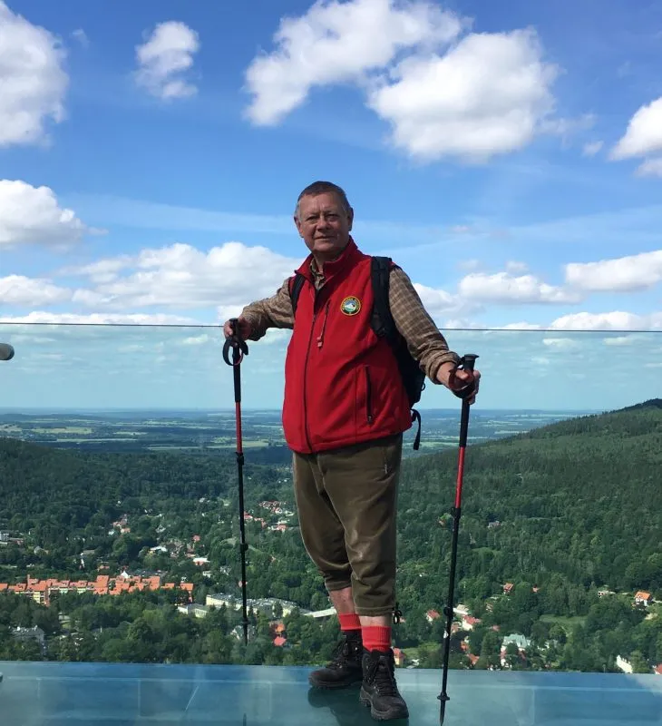 meżczyzna w czerownym polarze stojący na przeszklonej podłodze wysoko na ziemia
