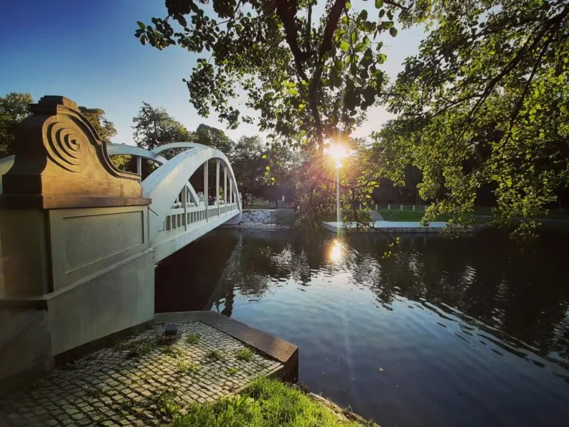 Un ponte su un fiume circondato dal verde prima del tramonto