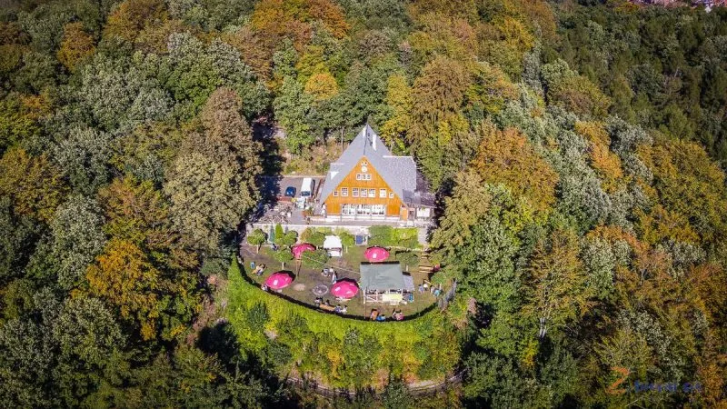 widok z drona na pomarańczowe schronisko otoczone lasami