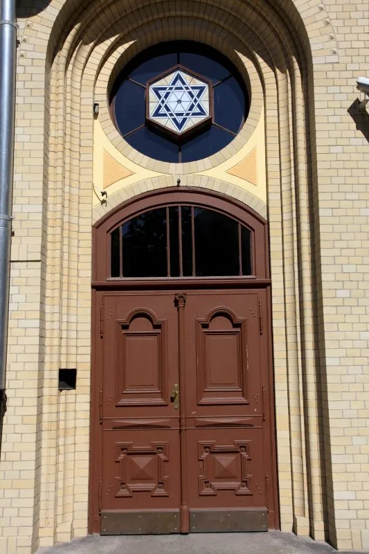 Główna wejście do synagogi z klasycystycznymi łukowym wejściem. Nad drewnianymi drzwiami rozeta z Gwiazdą Dawida.