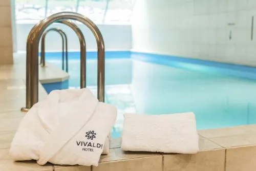 Basen wewnętrzny. Przy drabince położone ręczniki z logo i nazwą hotelu.