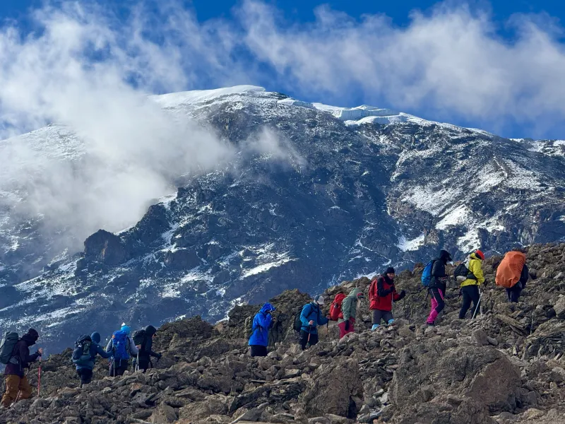 A group of hikers is walking uphill