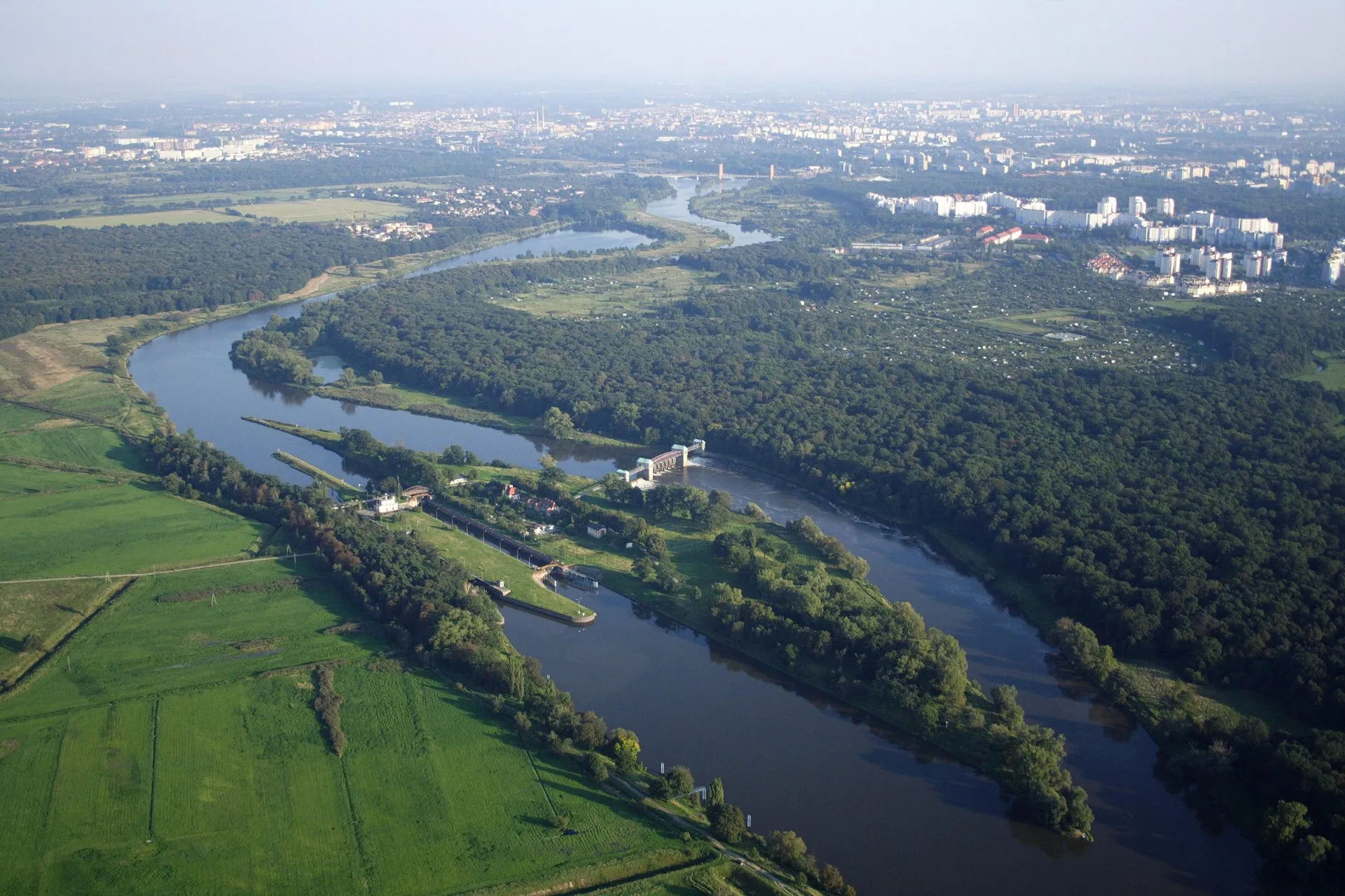 widok z drona na szeroką rzękę, na której znajduję się podłużna wyspa