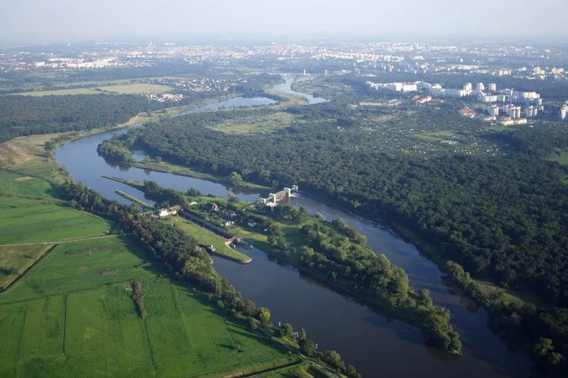 widok z drona na szeroką rzękę, na której znajduję się podłużna wyspa