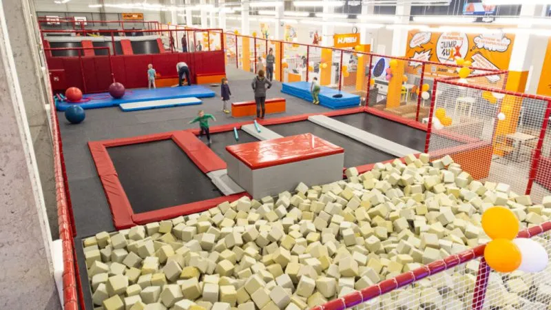 Park trampolin z kilkunastoma dużymi trampolinami, basenem wypełnionym gąbkami.