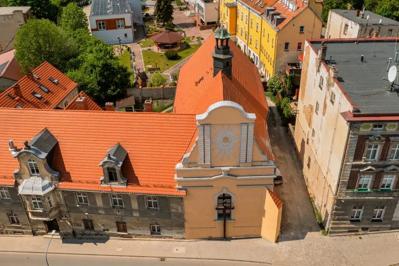 Widok z lotu ptaka na cerkiew - budowla z kamienia i cegły, o gotyckim prezbiterium z ostrołukowym portalem i strzelistym, oskarpowanym zewnętrzem