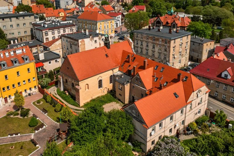 Widok z lotu ptaka na cerkiew - budowla z kamienia i cegły, o gotyckim prezbiterium z ostrołukowym portalem i strzelistym, oskarpowanym zewnętrzem