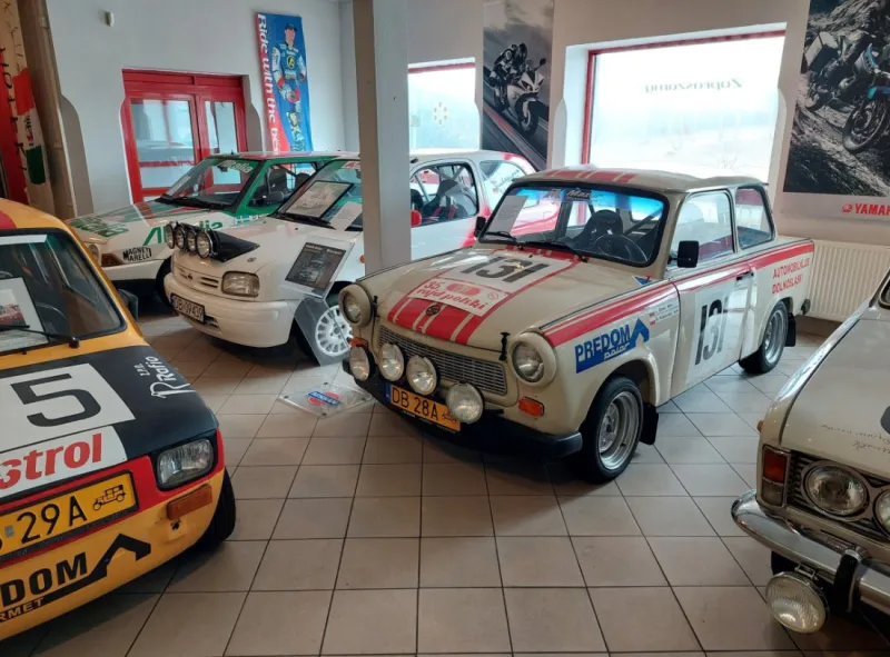 V sále Muzea hornictví a motoristických sportů ve Valbřichu stojí historické soutěžní vozy se startovními čísly, nálepkami sponzorů a historickým vybavením.