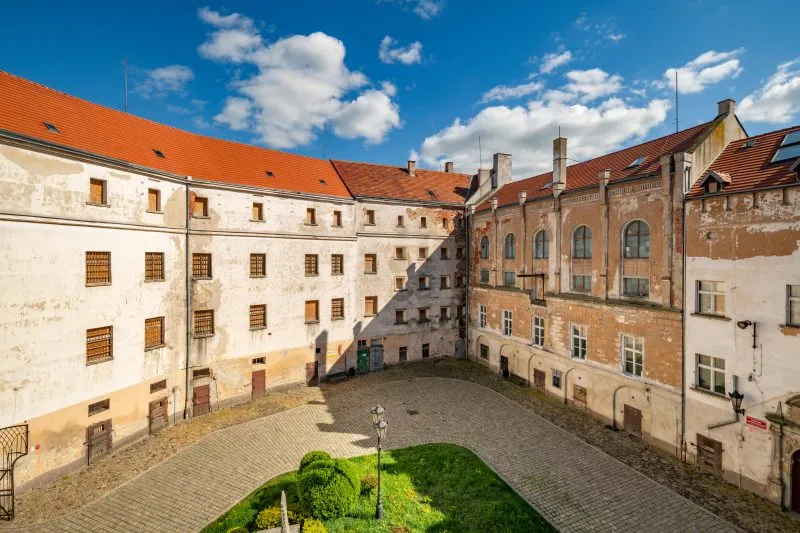 Na zdjęciu Zamek Piastowski w Jaworze wygląda jak solidna, jasnokamienna twierdza z wysoką, prostokątną wieżą i równymi murami dominującymi nad otoczeniem.