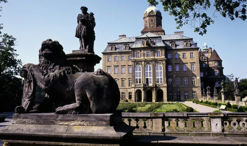 Nieaktualne zdjęcie fasady zamku książ z widoczną kamienną rzeźbą przed wejściem