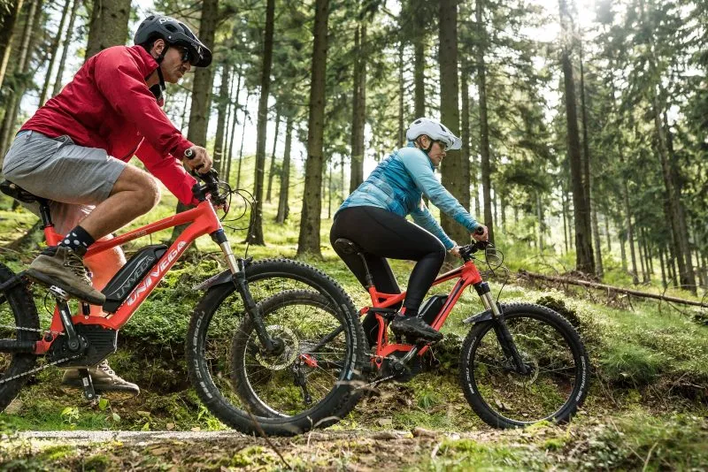 Dwójka rowerzystów podczas jazdy uchwycona od boku