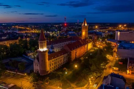 Widok z drona na oświetlony sztucznym światłem Zamek Piastowski w Legnicy