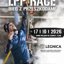 Dynamiczny plakat sportowy, którego lewą stronę zajmuje zdjęcie mężczyzny w sportowym stroju, pokonującego wiszącą przeszkodę na biegu OCR. Uczestnik, w ciemnoniebieskiej koszulce, czarnych rękawkach, kominie i opasce na głowie z numerem 137, ma na policzku wymalowaną czerwoną liczbę "17". Z wysiłkiem i skupieniem patrzy w górę, trzymając się jedną ręką elementów konstrukcji z łańcuchami i czerwonymi chwytami. Prawą stronę plakatu spowija gęsta, biała chmura dymu lub pyłu, na tle której umieszczono czarny, poszarpany pas z białą datą "17 | 10 | 2026" i dopiskiem o miejscu wydarzenia w Legnicy o godzinie 11:00. Na samej górze plakatu dominują wielkie, białe, "zniszczone" napisy "L.P.P. RACE" oraz "BIEG Z PRZESZKODAMI". W prawym dolnym rogu, na jasnym, zadymionym tle, widnieje herb i nazwa miasta LEGNICA oraz informacja o patronacie honorowym prezydenta Macieja Kupaja