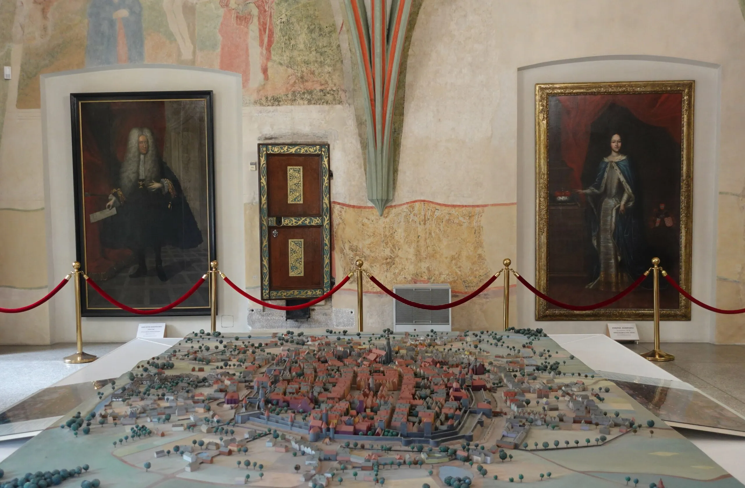stara makieta miniaturowa ukazująca dawne miasto. w tle widać obrazy