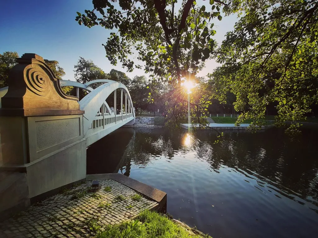 Un pont enjambant une rivière, entouré de verdure, avant le coucher du soleil.