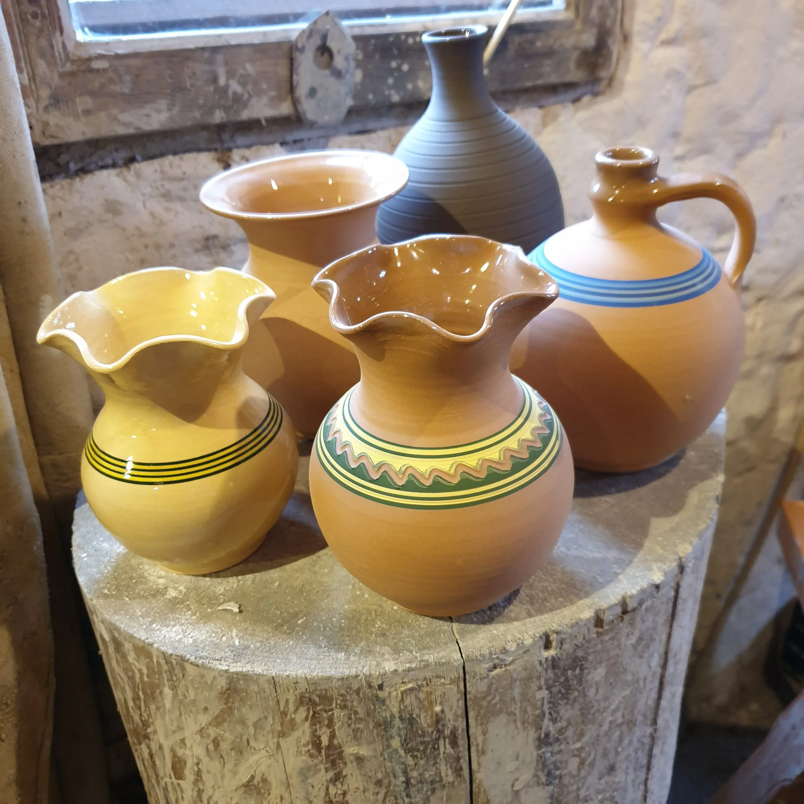 Ceramiczne dzbany stojące na pieńku
