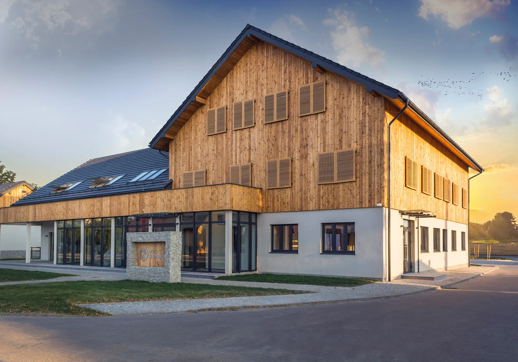 Nowoczesny budynek hotelu, z elewacją obłożoną drewnem.