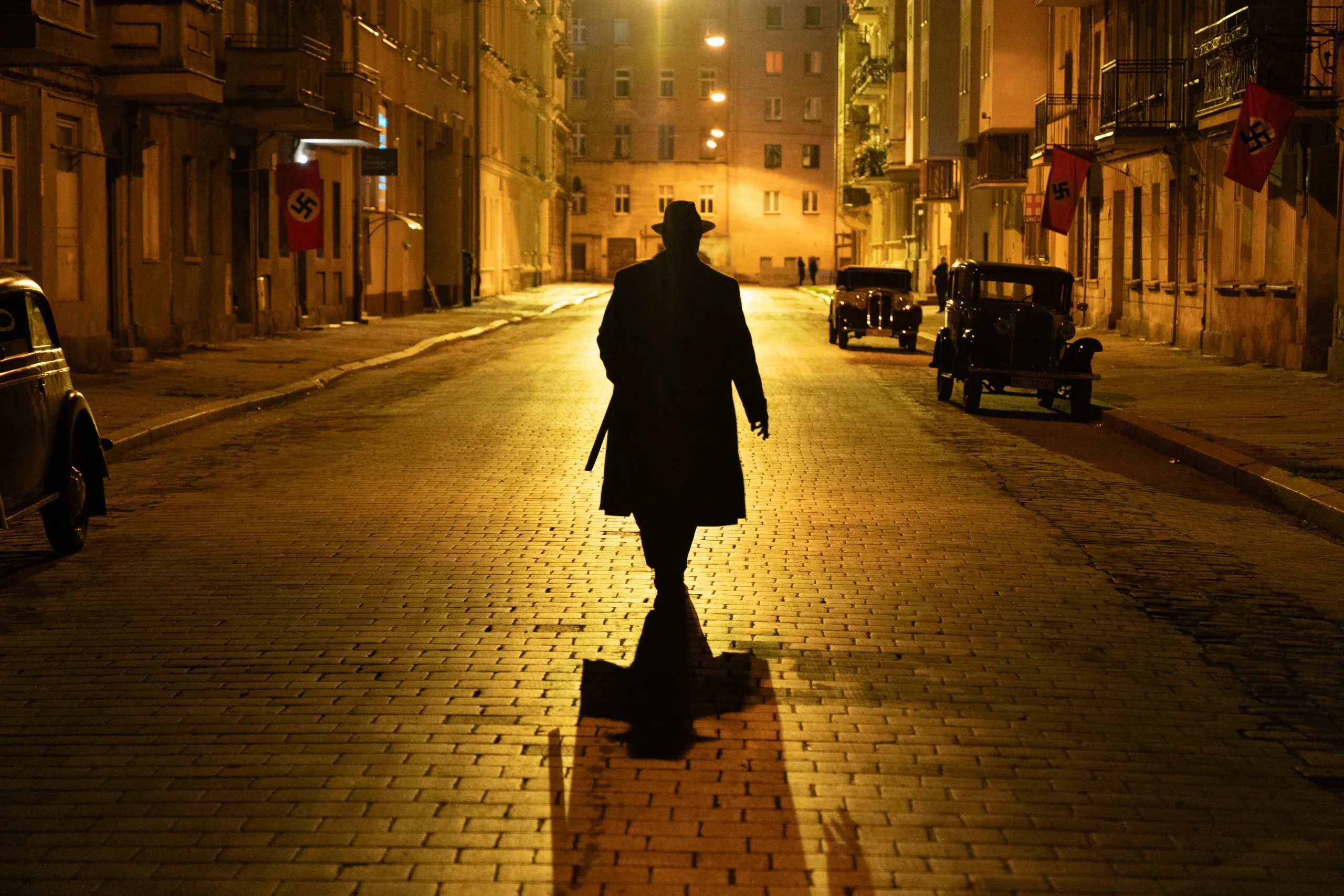 Kadr z filmu z mężczyzną spacerującym nocnymi ulicami miasta z lat 30-tych