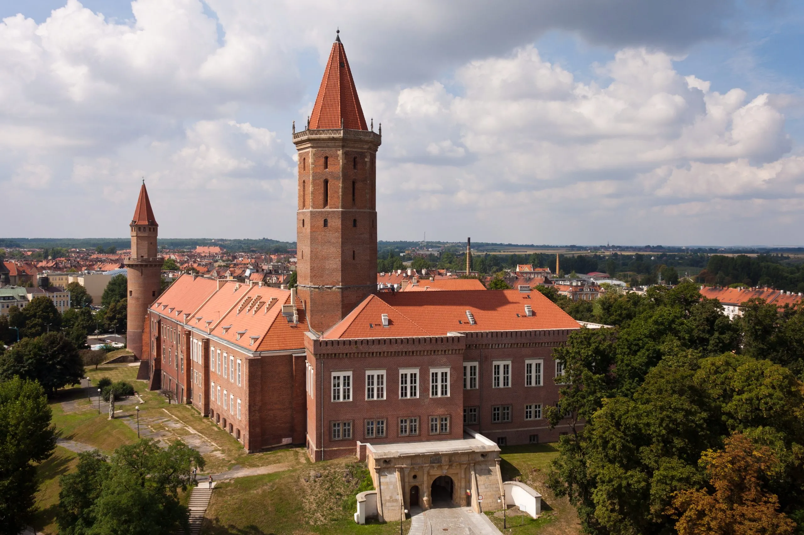 Bryła zamku piastowskiego w Legnicy z masywną wieżą nakrytą hełmem.